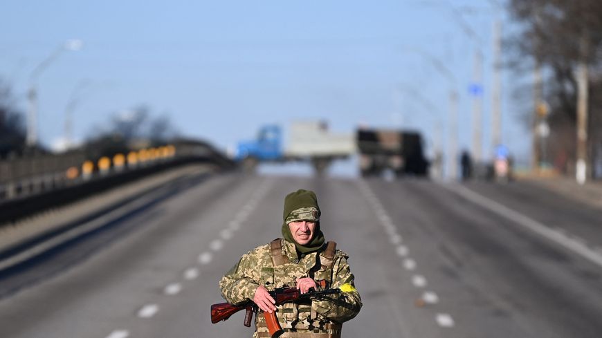 Un militaire ukrainien patrouille sur une route de l'ouest de Kiev le 26 février 2022. L'armée régulière est désormais appuyée par des dizaines de milliers de réservistes et volontaires.