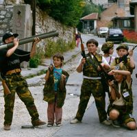 Des enfants Bosniens à Sarajevo, en juillet 1992, jouant avec de fausses armes.
