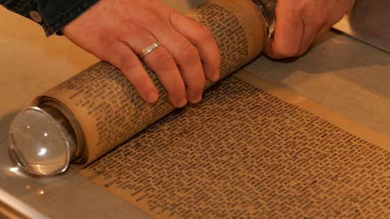 Le conservateur enroule soigneusement le manuscrit de "Sur la route" long de près de 11 mètres. ©Getty - Michael Macor / San Francisco Chronicle