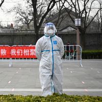 Un agent de santé en tenue de protection regarde un site de test Covid-19 à Pékin le 23 mars 2022.