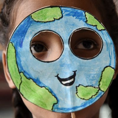 Une élève indienne cachée sous un masque représentant la terre lors de la journée mondiale de la Terre