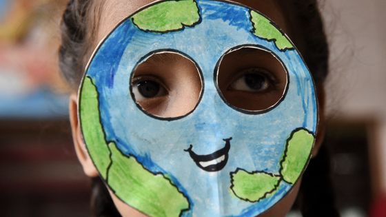 Une élève indienne cachée sous un masque représentant la terre lors de la journée mondiale de la Terre ©AFP - NARINDER NANU