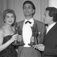 21 juillet 1953 : Jacqueline François et Charles Aznavour recevant de Gilbert Bécaud, le prix des 'Bravos du Music-Hall' à Paris