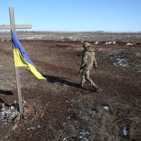 Un soldat ukrainien passe devant un mémorial construit pour l'occasion, à Svetlodarsk, près de Donetsk, le 12 mars 2022.