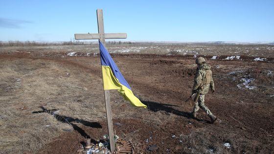 Un soldat ukrainien passe devant un mémorial construit pour l'occasion, à Svetlodarsk, près de Donetsk, le 12 mars 2022. ©AFP - Anatolii Stepanov