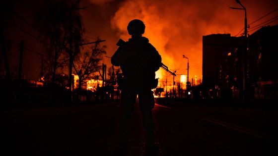 Un soldat des Forces spéciales ukrainiennes devant une station-service bombardée par les russes à Kharkiv ©AFP - FADEL SENNA