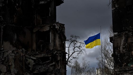 Le drapeau ukrainien flottant entre deux bâtiments détruits par des bombardements russes à Borodyanka le 17 avril 2022 ©AFP - Sergei SUPINSKY