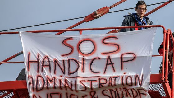 Un père a accroché des banderoles sur une grue pour sensibiliser aux problèmes administratifs de son fils, atteint d'une maladie mentale. ©AFP - Fred SCHEIBER