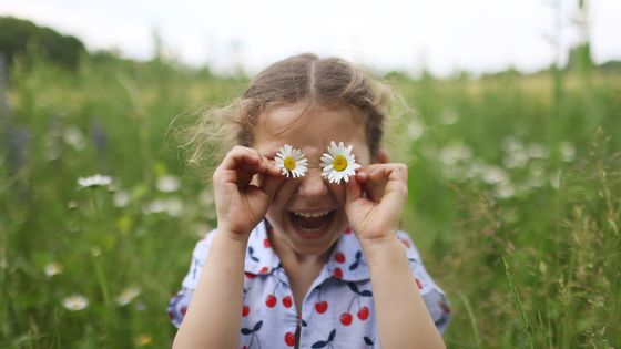 Une enfant de cinq ans heureuse de vivre, dans un champ de pâquerettes ©Getty - Catherine Delahaye