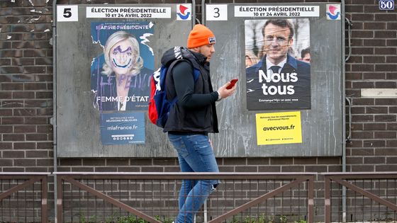 Un homme passe devant les affiches des deux candidats indiffèremment ©Getty - getty