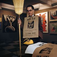 Man Ray entouré de quelques-unes de ses œuvres, à Paris en 1956.