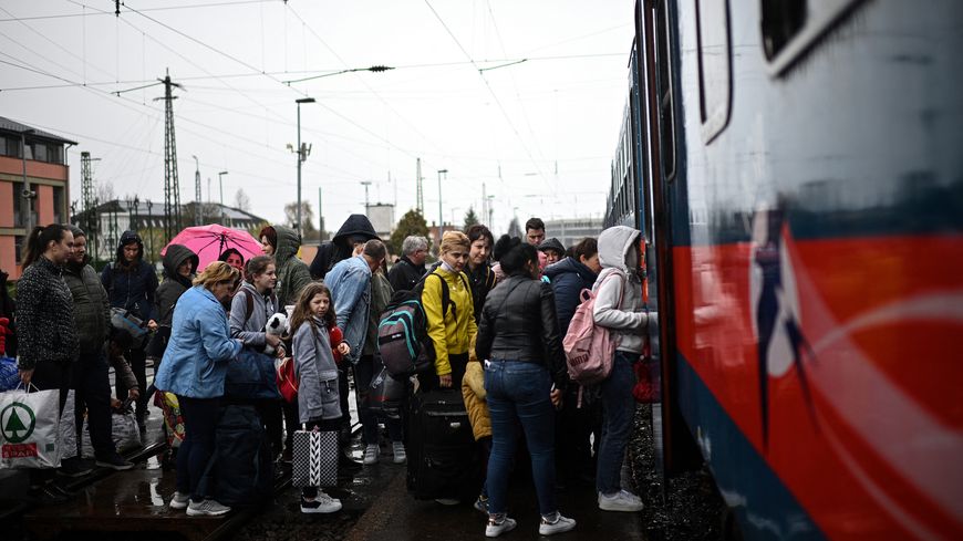 Des réfugiés ukrainiens montent à bord d'un car à la frontière hongroise