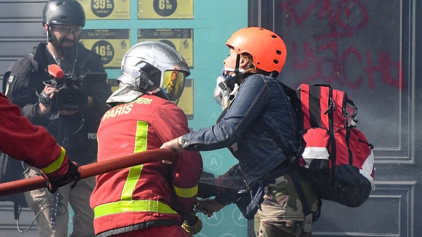 Un sapeur-pompier aux prises avec une manifestante en marge d'un défilé, à Paris, le 1er mai 2022.