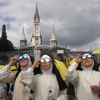 Des religieuses péruviennes en pèlerinage à Lourdes regardent la dernière éclipse du soleil du millénaire sur le continent européen, le 11 août 1999.