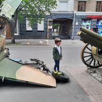 Un enfant pose devant des trophées de guerre de l'armée ukrainienne dans les rues de Kiev (Ukraine)