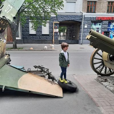 Un enfant pose devant des trophées de guerre de l'armée ukrainienne dans les rues de Kiev (Ukraine)