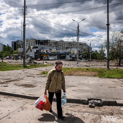 Une femme porte des sacs contenant de la nourriture alors qu'elle marche dans le quartier détruit de Saltivka, au nord de Kharkiv, le 17 mai 2022.