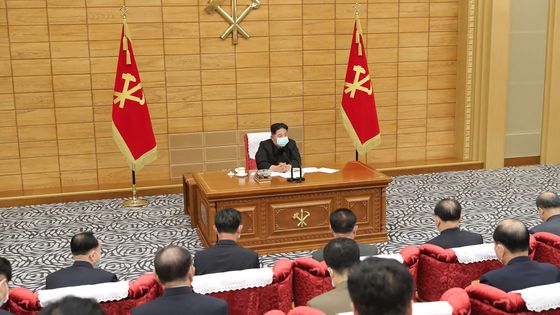 Le leader nord-coréen Kim Jong-un apparaît masqué à une réunion le 14 mai, photo diffusée par l’agence de presse de Pyongyang. ©AFP - STR / KCNA VIA KNS