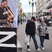 Passants à Moscou à côté d’un t-shirt à l’effigie de Vladimir Poutine et du signe « Z » de l’« opération spéciale » en Ukraine.