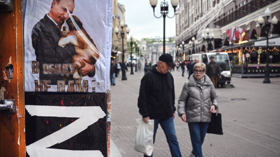 Passants à Moscou à côté d’un t-shirt à l’effigie de Vladimir Poutine et du signe « Z » de l’« opération spéciale » en Ukraine. ©AFP - Alexander NEMENOV / AFP