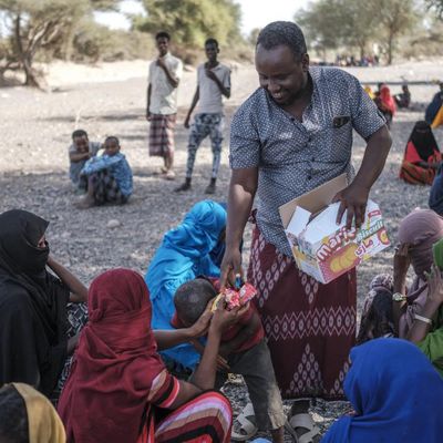 Un homme distribue de la nourriture dans un camp de personnes déplacées dans la région de Semera (Ethiopie) le 15 février 2022