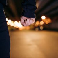 Main sur la défensive, poing serré en ville dans la nuit