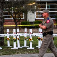 Un policier passe devant un mémorial de fortune en hommage aux victimes de la fusillade de la Robb Elementary School à Uvalde, Texas. 26/05/2022