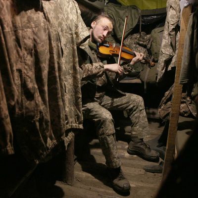 Un militaire ukrainien jouant du violon dans la région de Donetsk, en décembre 2020