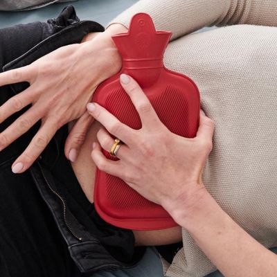 Une bouillote appliquée sur le ventre d'une femme à cause de règles douloureuses.
