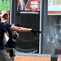 Deux agents du FBI étudient les impacts de balles après la tuerie raciste de Buffalo.