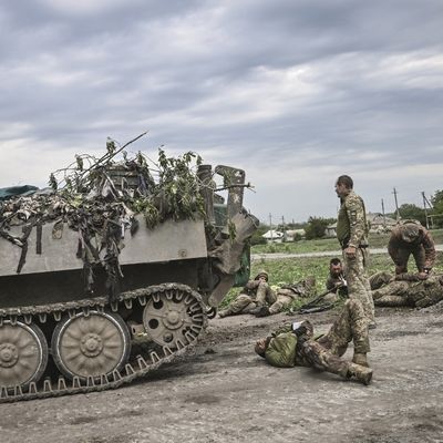 Des militaires ukrainiens assistent leurs camarades non loin de la ligne de front dans la région du Donbass, à l'est de l'Ukraine, le 21 mai 2022.