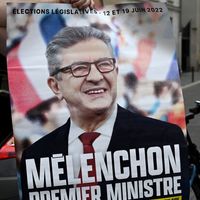 Un militant de La France Insoumise avec une affiche de campagne indiquant "Mélenchon, Premier ministre" devant le siège de LFI à Paris le 3 mai 2022