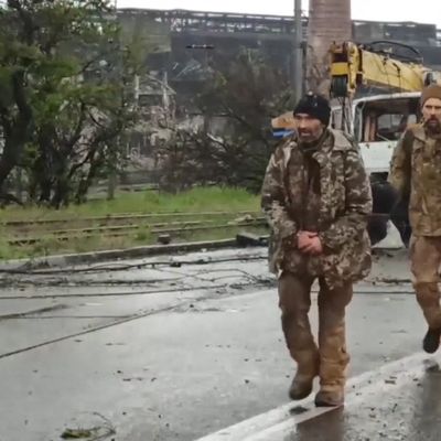 Des soldats ukrainiens du bataillon Azov marchent sur une route dans la ville portuaire de Marioupol, contrôlée par la Russie.