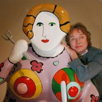 Niki de Saint Phalle posant auprès d'une de ses "Devouring Mothers" (Mères dévoreuses), en 1998.