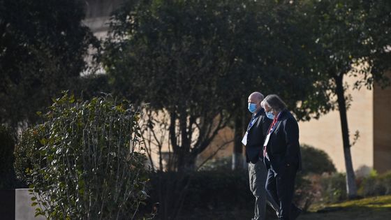 Peter Daszak, à gauche, le 29 janvier 2021 à Wuhan, alors chargé par l'OMS d'enquêter sur l'origine du Covid, avec une équipe de scientifiques ©AFP - Hector RETAMAL / AFP