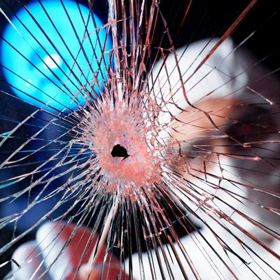 Forensics officer using swab to collect evidence from broken window