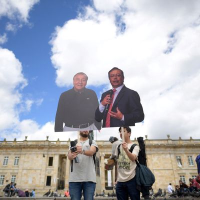 Deux hommes avec des affiches à l'effigie des deux candidats en lice pour le second tour des élections présidentielles en Colombie.